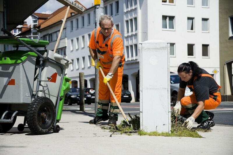 Mitarbeiter vom Osnabrücker ServiceBetrieb reinigen in der Innenstadt einen Fußweg